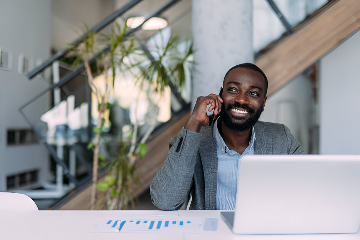 Business talk. Businessman sitting at desk and talking on the phone