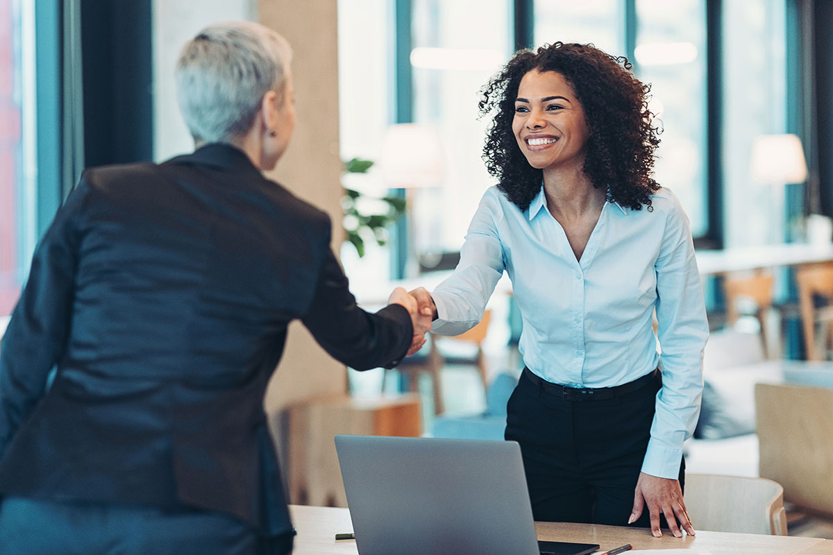 Businesswomen-shaking-hands-in-the-office– Two business professionals shaking hands after an agreement